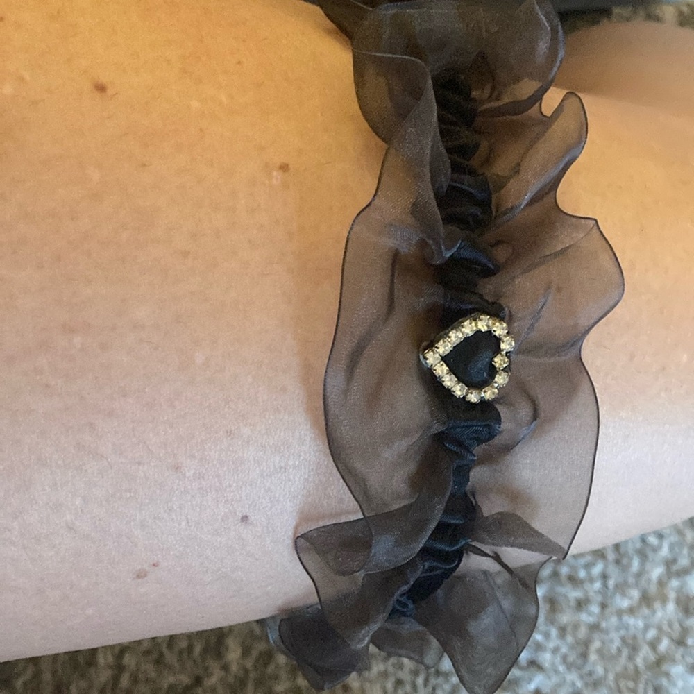 Heart-shaped gemstone on black sheer garter belt